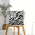 Black and white zebra print throw pillow on a modern sofa