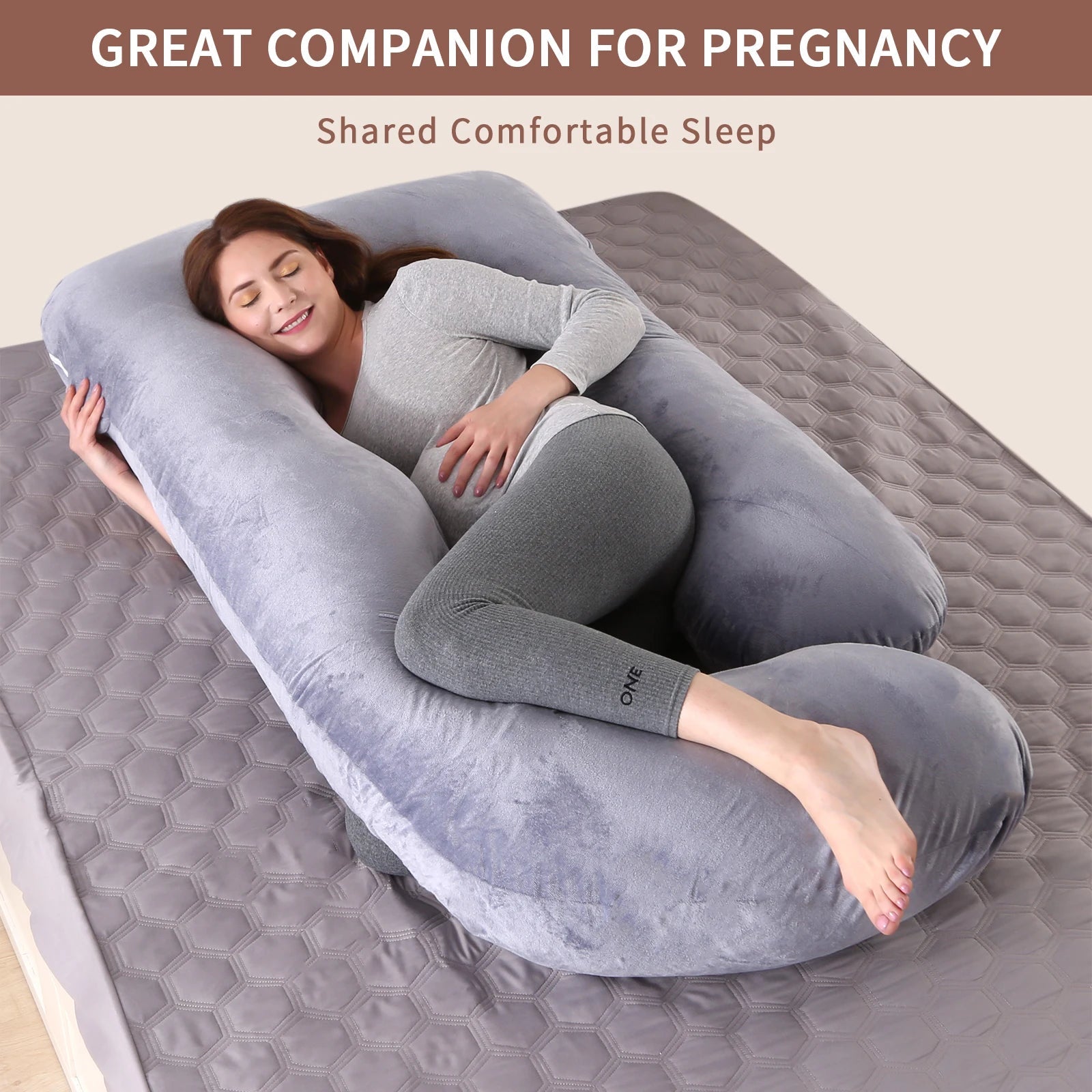 G-shaped full body pregnancy pillow with removable cover on a neatly made bed